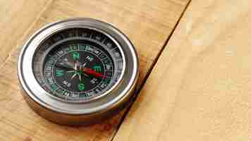 Free photo high angle compass on wooden board with copy-space