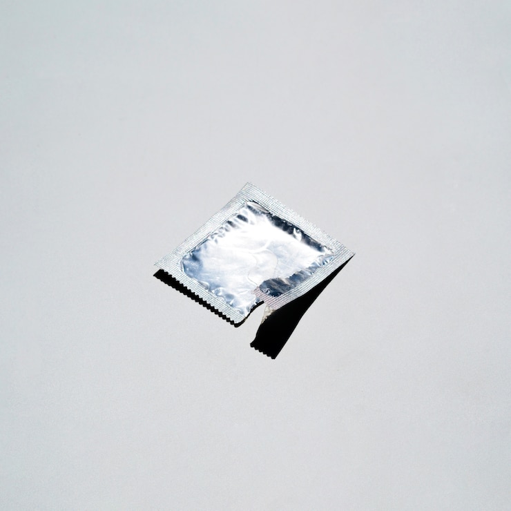 Free Photo high angle condom wrapper on white background