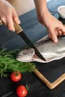 Free photo high angle cook cleaning fish in kitchen