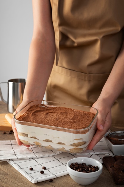 High angle cook holding tiramisu tray