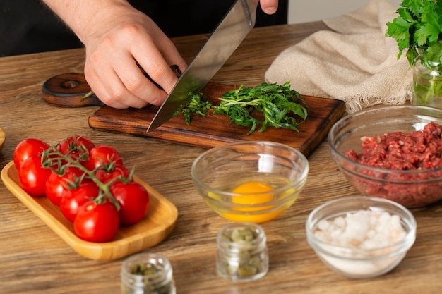 Free photo high angle cook preparing beef steak tartar