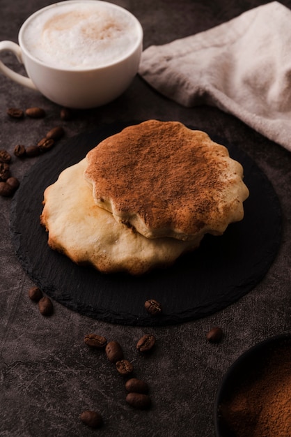 Alto angolo di biscotti con cacao in polvere sulla cima