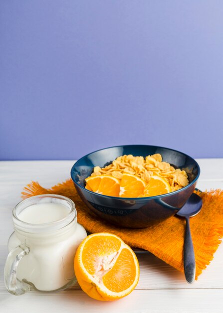 High angle cornflakes with orange and yogurt