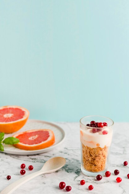 High angle cornflakes with yogurt and citrus in glass