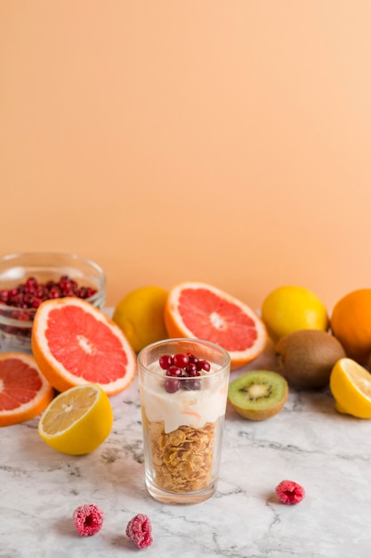 High angle cornflakes and yogurt in glass with fruits