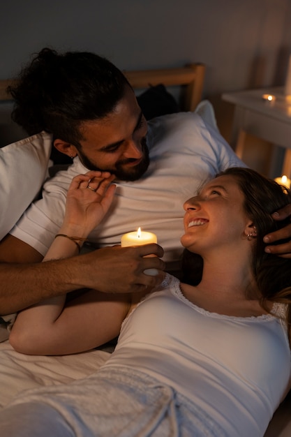 High angle couple in bed with candle