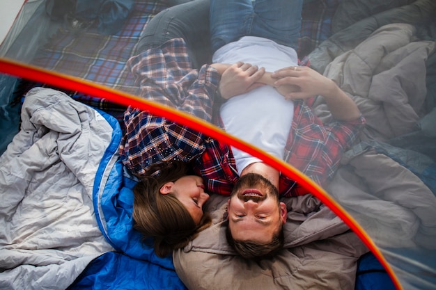 Free photo high angle couple camping in tent