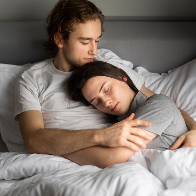 Alto angolo delle coppie che stringono a sé a letto