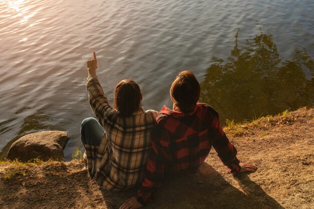 High angle couple sitting by the lake