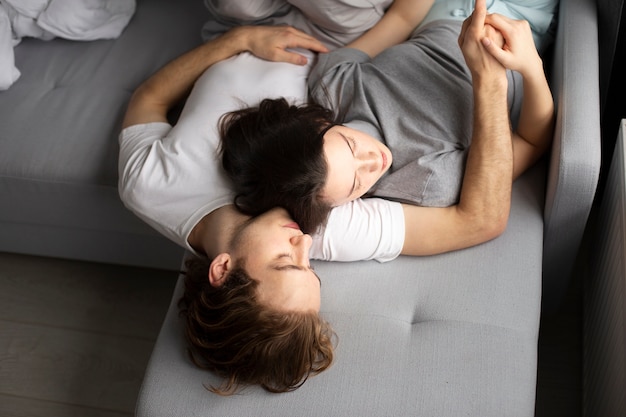 High angle of couple sleeping on sofa