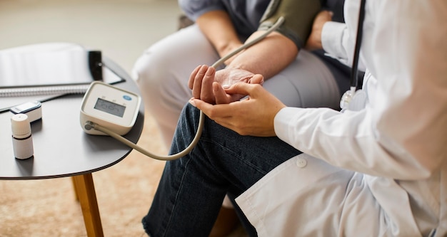 高齢患者の血圧をチェックする高角度のcovid回復センターの女性医師