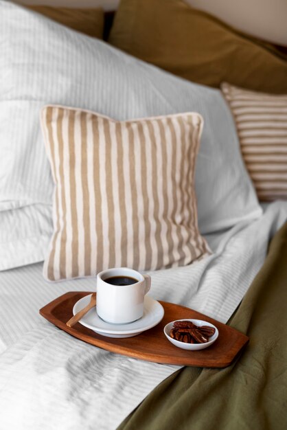 Free photo high angle cozy bed arrangement with coffee cup