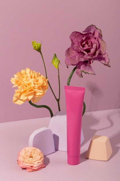 Free photo high angle cream container and flowers