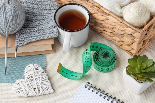 Free photo high angle of crochet set with yarn and measuring tape