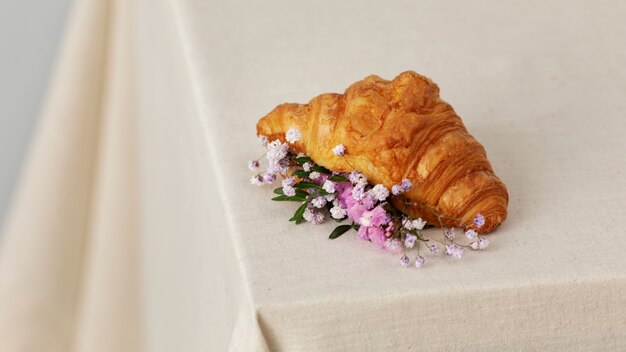 High angle croissant and flowers on table