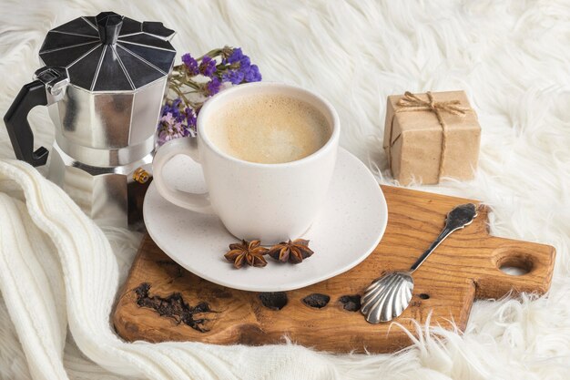 Free photo high angle of cup of coffee with present and kettle