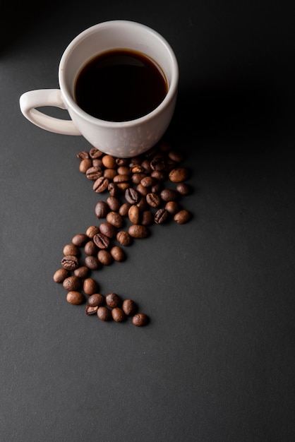 High angle cup of coffee with roasted beans