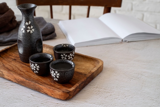 High angle cups and bottle on wooden board