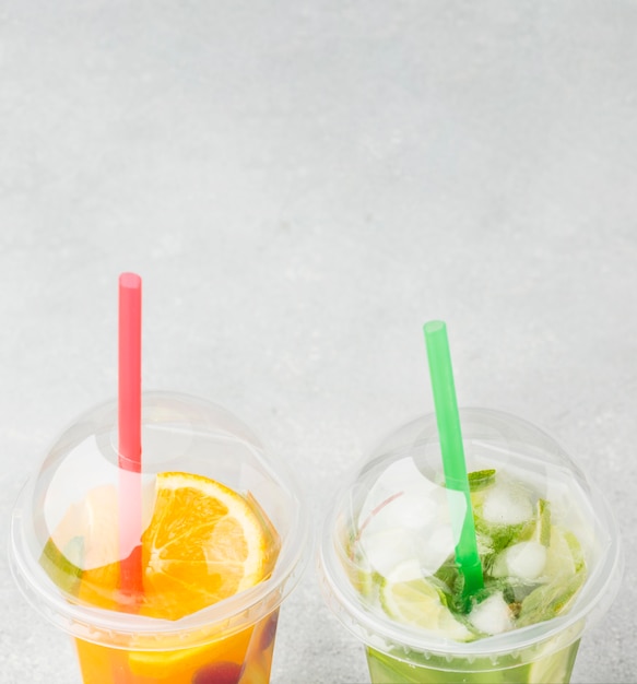 High angle of cups with soft drinks and straws