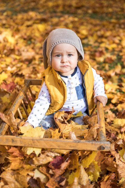 High angle cute baby with hat sitting outdoors