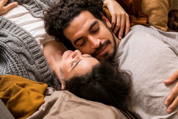 High angle cute couple lying together on the sofa