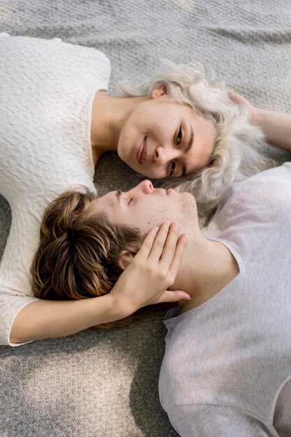 Высокий угол милой пары, расслабляющейся вместе на открытом воздухе на одеяле