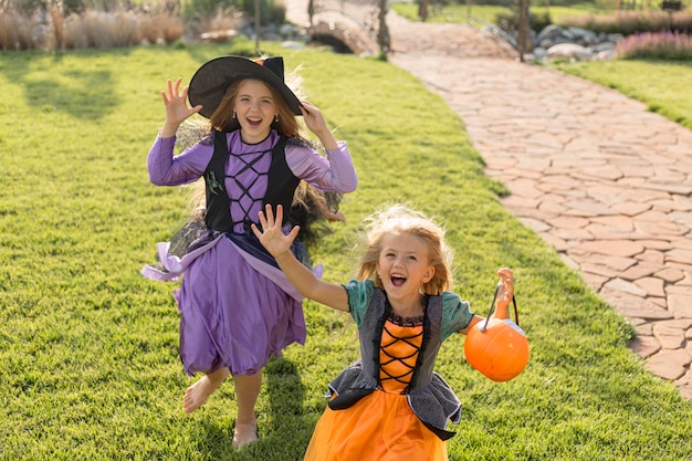 High angle of cute little girls with halloween costumes