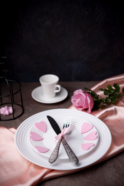 High angle of cutlery on plates with hearts and copy space