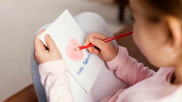 High angle of daughter drawing card for father's day