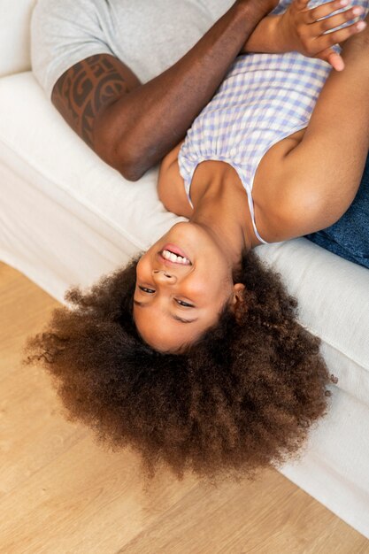 High angle of daughter and father relaxing at home