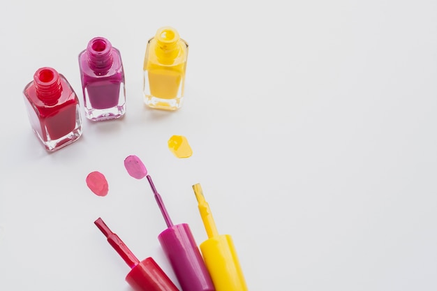 High angle decoration with nail polishes on white background