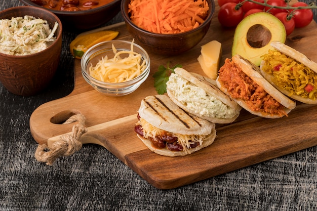 Free photo high angle delicious arepas on wooden board