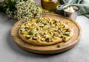 Free photo high angle of delicious cooked pizza with chamomile flowers