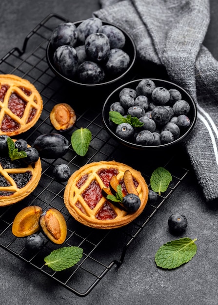 High angle of delicious pies with plums on cooling rack