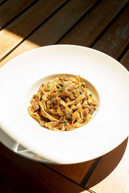High angle of delicious tagliatelle pasta on wooden table