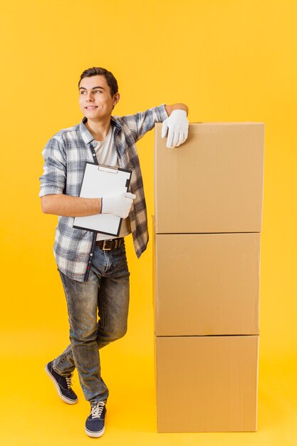 High angle delivery man beside stack of packages