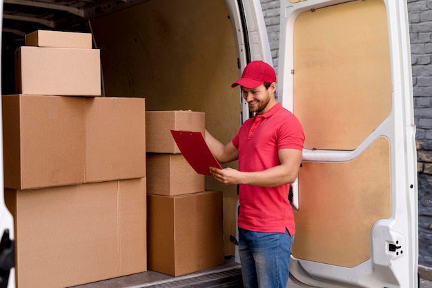 High angle delivery man checking packages list