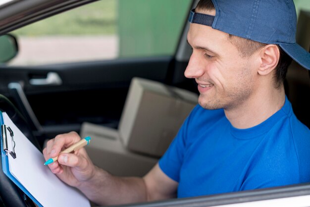 High angle delivery man signing paper