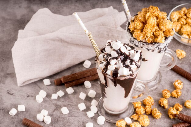 High angle of desserts in jars with marshmallows and popcorn