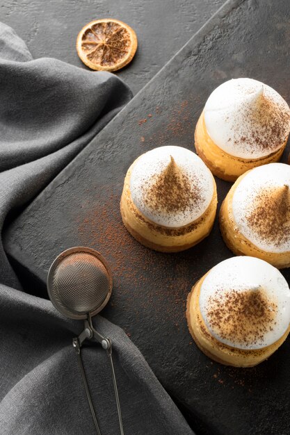 High angle of desserts on slate with cocoa powder and sieve