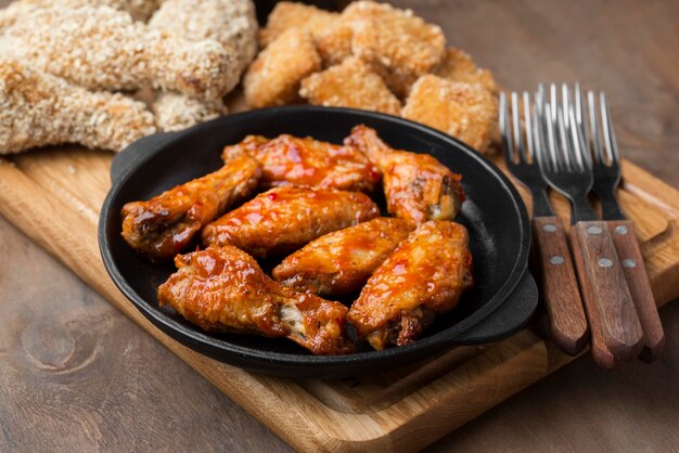 High angle of different types of fried chicken with cutlery