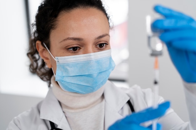 High angle doctor holding syringe and vial