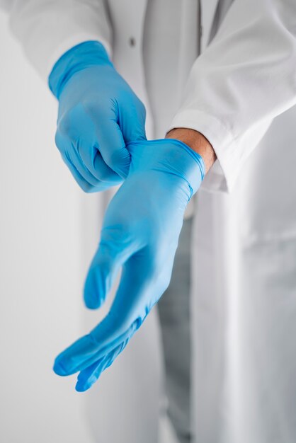 High angle doctor putting on gloves