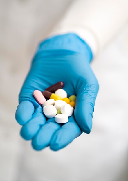 High angle of doctor with surgical glove holding pills