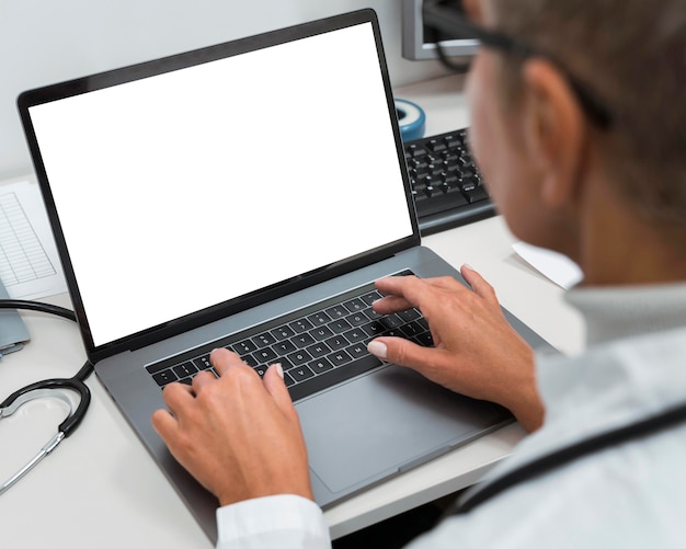 Free photo high angle doctor working on a laptop