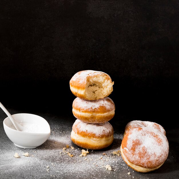High angle of donuts with bite mark and powdered sugar