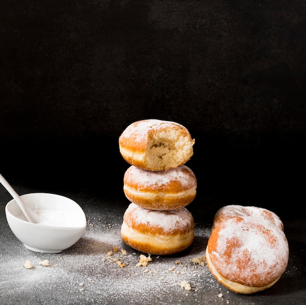 High angle of donuts with bite mark and powdered sugar