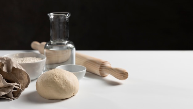 Free photo high angle of dough with rolling pin and ingredients