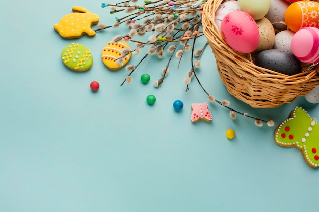 High angle of easter eggs in basket with bunny and butterfly shapes