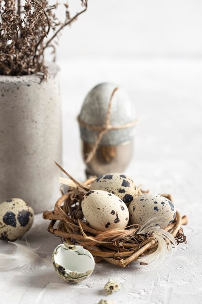 High angle of easter eggs in twigs nest with vase of flowers